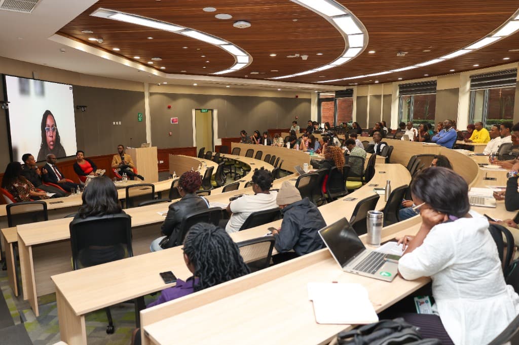 Health AI Roundtable in a lecture hall with panelists and a hybrid video participant